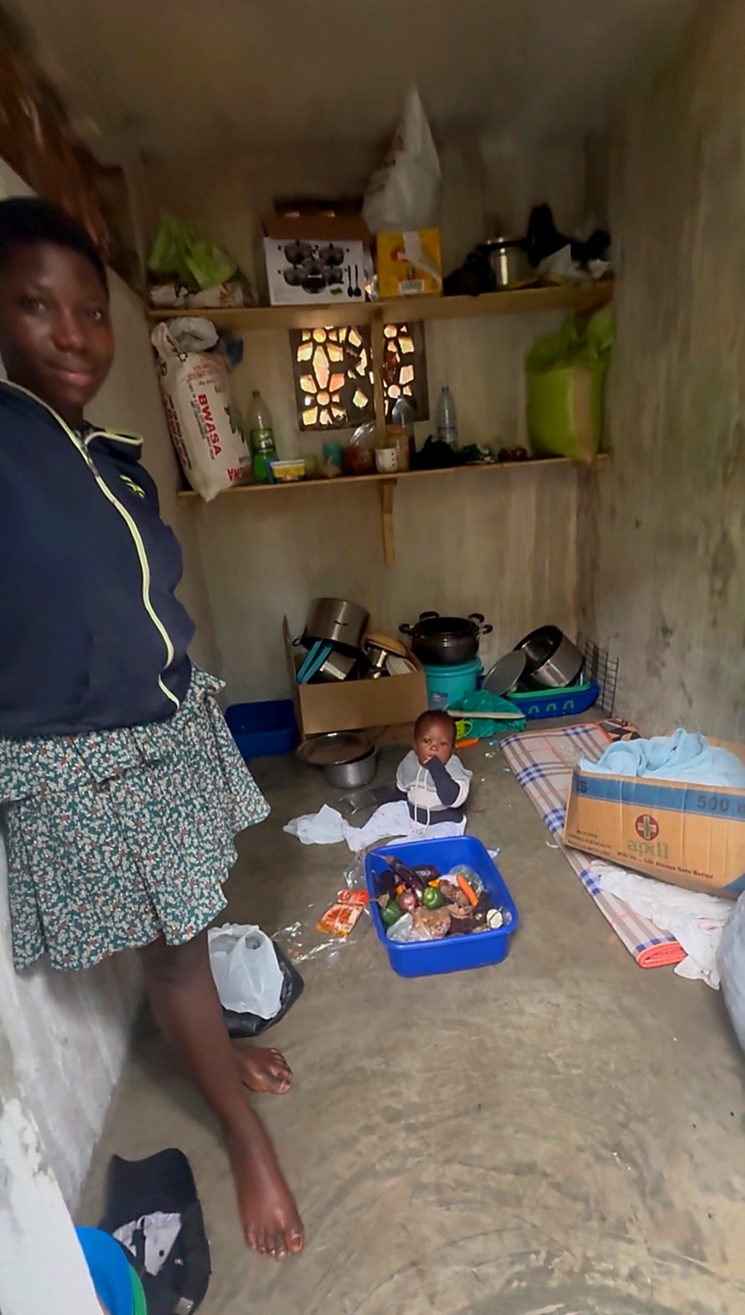 A young woman standing in the Grace Care community kitchen with fresh vegetables and cookware